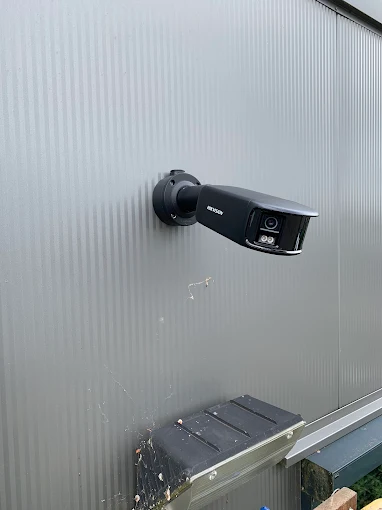 Beveiligingscamera met dubbele lens gemonteerd op de gevel van een bedrijfspand